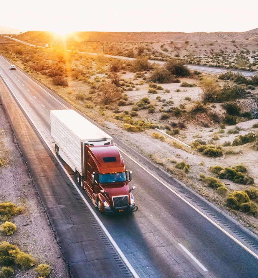 overview of red commercial truck driving at sunset